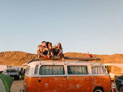 friends sitting atop an RV at joshua tree music festival 