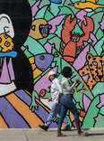 Pedestrians walk past a mural near 3rd St. in Koreatown.