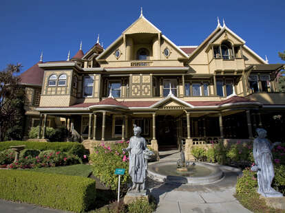 Winchester Mystery House victorian mansion exterior with a statue in front of it