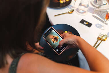 Woman taking a photo of a dish at Once Upon a Kitchen