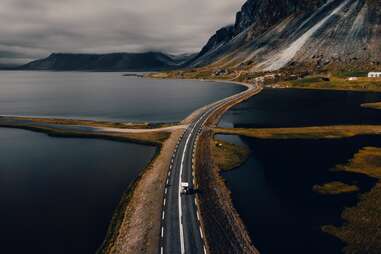 car driving down scenic road in iceland