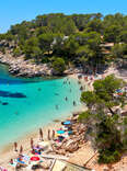 People enjoying vacations in the Cala Salada lagoon in Ibiza, Balearic Islands, Spain