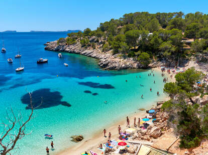 People enjoying vacations in the Cala Salada lagoon in Ibiza, Balearic Islands, Spain
