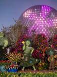Topiaries of the Encanto movie characters in front of the Epcot ball at Disney World. 