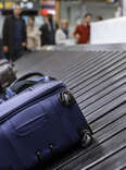 Blue luggage on the baggage claim carousel 