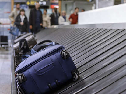 Blue luggage on the baggage claim carousel