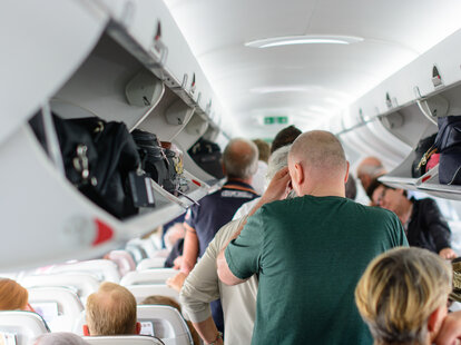 People stressed and waiting to disembark a packed flight.