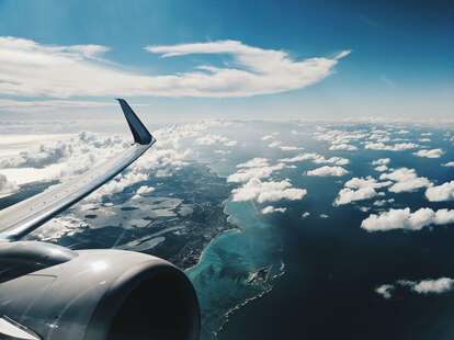 The view from an airplane of the wing, flying over The Bahamas. 