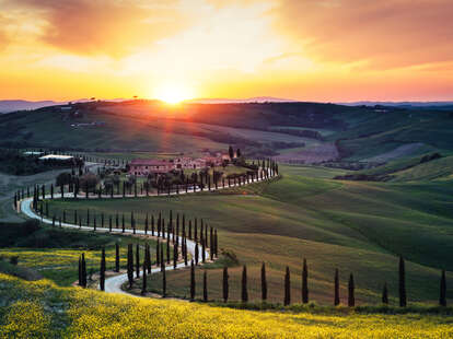 Tuscany landscape with winding country road at sunset