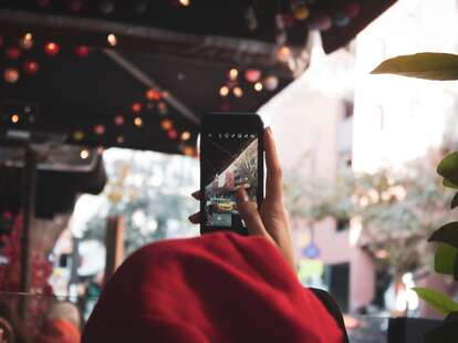 person holding up a phone at city scenery for an instagram story