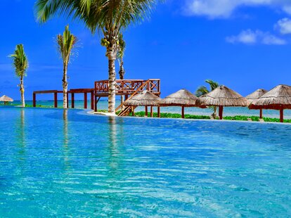 A view of a resort pool deck overlooking the ocean.