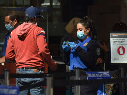 TSA officer checks a man’s ID at an airport security checkpoint