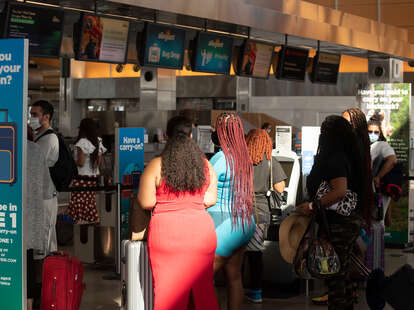 A group of African Americans wait for assistance at a check in counter at RDU International airport.
