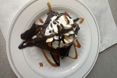 Chocolate cake with caramel, fudge, and whipped cream