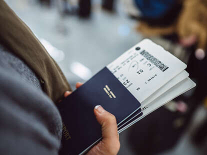 Woman’s hands holding a passport and boarding passe