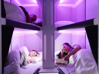 Air New Zealand's new cabin concept, called the Skynest, where three people can be seen laying down. 