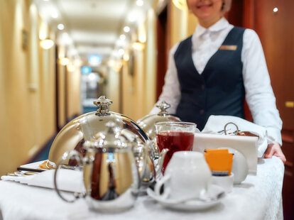 Room service getting delivered with a tray of food in a room of hotel.