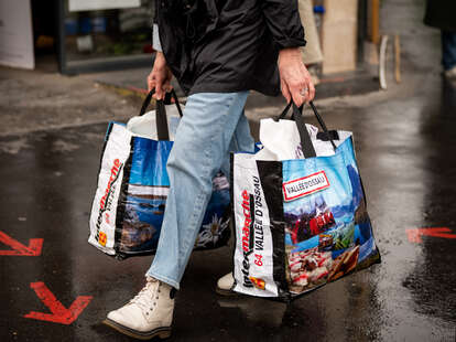 A shopper carries Intermarche branded reusable bags in Paris