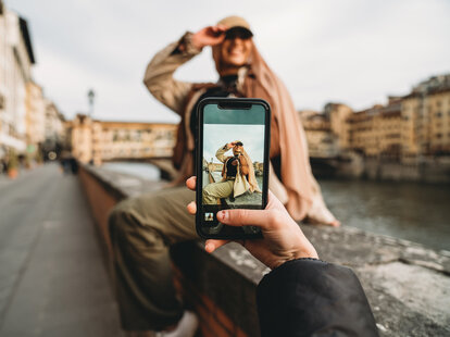 A young adult woman is taking a picture to her friends