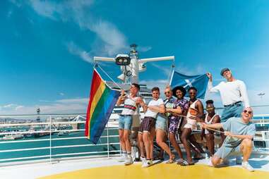 happy cruise ship passengers with a Pride flag