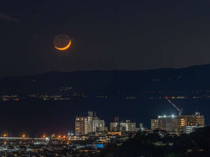 Crescent moon in the night sky over the residential district in Kanagawa, Japan