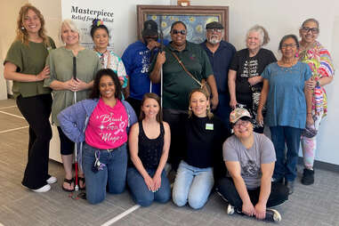 Group poses with smiles at Envision Arts Gallery and Community Engagement Center
