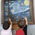 Two children touch art at Envision Arts Gallery