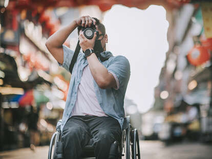 Man in wheelchair using camera