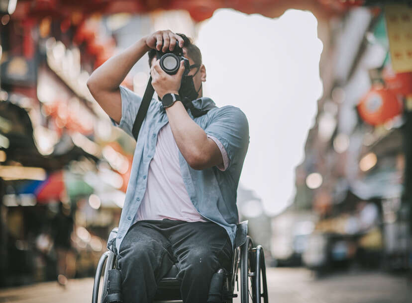 Man in wheelchair using camera