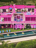 An aerial shot of the Barbie dream house which is ultra pink and decorated. 
