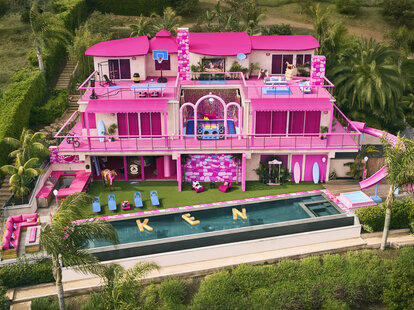 An aerial shot of the Barbie dream house which is ultra pink and decorated.