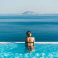 woman admiring ocean view from infinity pool 