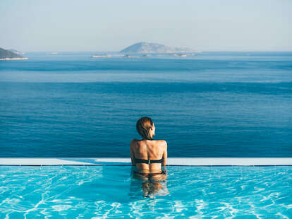 woman admiring ocean view from infinity pool 