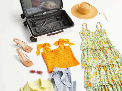 A selection of items outside of a suitcase packed for summer travel.