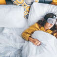 woman laying in bed with eye mask and iphone