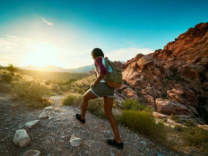 Woman hiking at Red Rock Canyon during sunset.