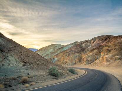 A highway in Death Valley, with the painted hills in the background.