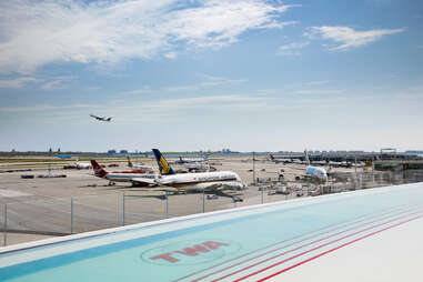 an rooftop nfinity pool that says TWA, with planes in the background at JFK airport