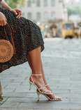 woman wearing heels and trendy straw bag