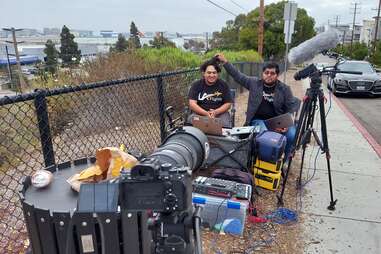 two sitting men, the stars of LA flights with camera and sound equipment