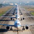 long line of airplanes on runway