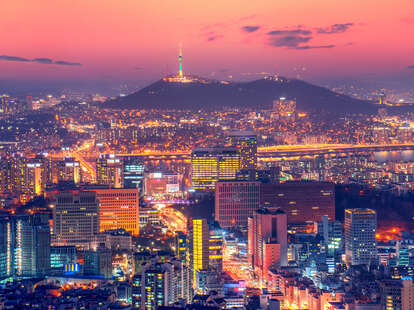 Downtown skyline of Seoul, South Korea with Seoul Tower at sunset.