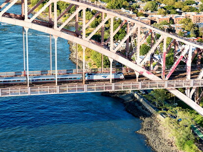 Aerial view of and Amtrak train crossing the Hell Gate Bridge in New York City.