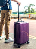 Passenger waiting for a taxi at the airport with suitcase
