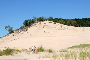 people climbing sand dunes at warren state park