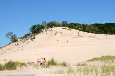 people climbing sand dunes at warren state park 