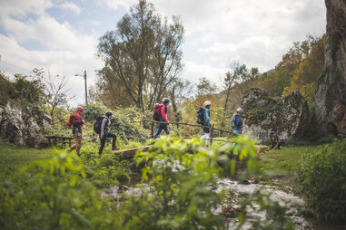 group of hikers crossing a bridge