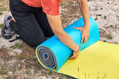 Person rolling up sleeping pad