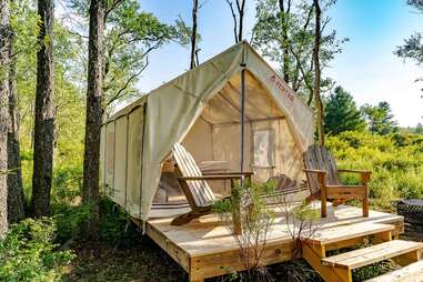 Tent on platform with Adirondack chairs in front