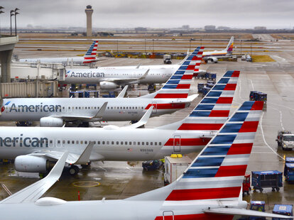American Airlines passenger jets parked at their gates on a rainy morning at Dallas/Fort Worth International Airport
